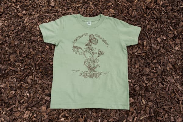 Light green men's t-shirt with butterfly logo on top of mulch