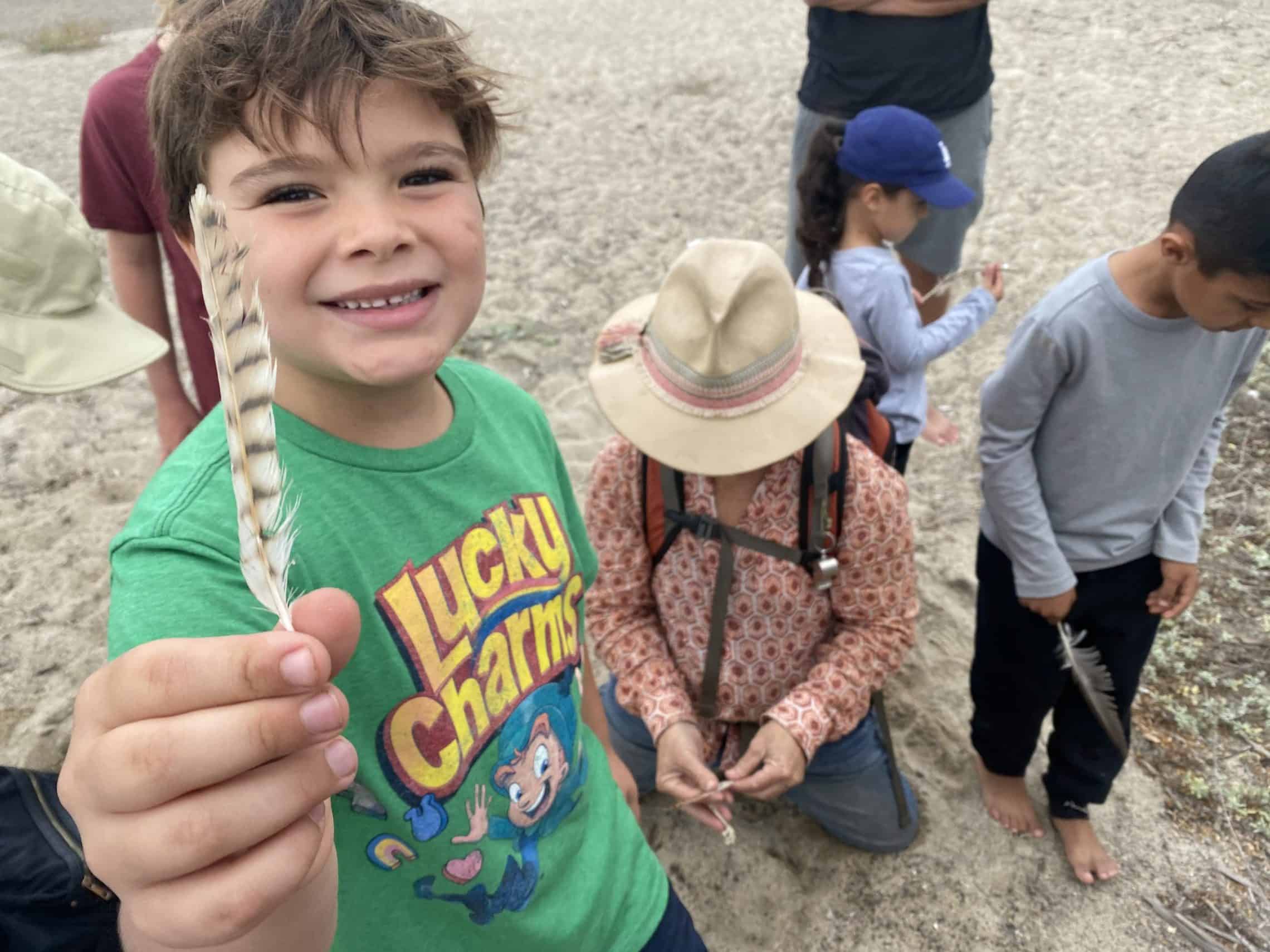 Child holding up a feather found on the Big Oak Canyon property