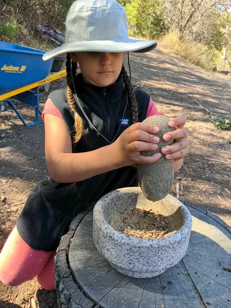 Earthroots student using mortar and pestal